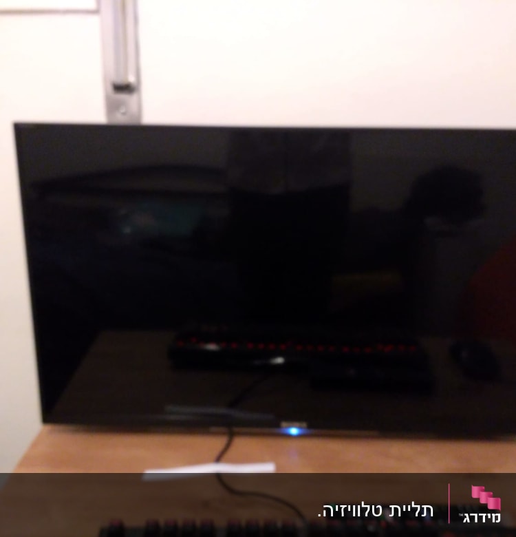 מסך טלוויזיה על שולחן עם שלטים ומקלדת